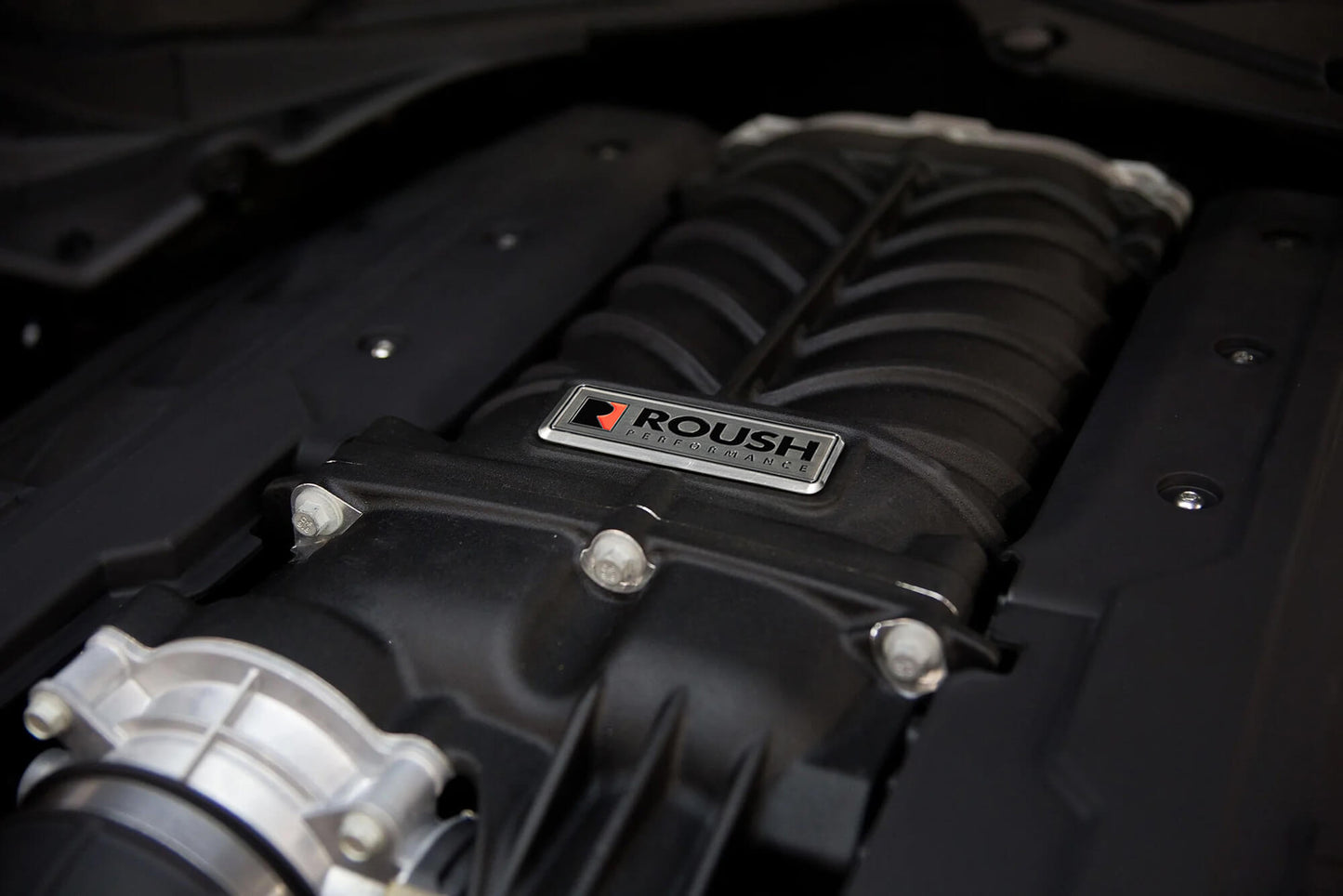 Close-up of a Roush Performance supercharger installed in a Mustang GT engine bay, ready to unleash 750 horsepower.