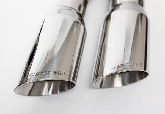 A close-up of two polished metal exhaust tips, crafted from 304 stainless steel and engraved with "ROUSH," shines on a light background. Ideal for a Roush F-150, these tips are part of the superior Cat-Back Exhaust system.
